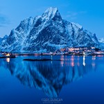 Reflection of Olstind mountain peak in harbour at Reine, Lofoten Islands, Norway