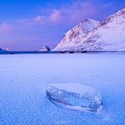 Block of ice on frozen Haukland beach in winter, Vestvagøy, Lofoten islands, Norway