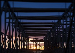 Silhouette shapes of empty cod drying racks at sunrise, Toppøy, near Reine, Moskenesøy, Lofoten Islands, Norway