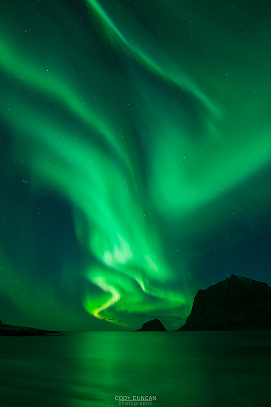 Northern Lights - Aurora Borealis shine in Sky over Vik Beach, Vestvågøy, Lofoten Islands, Norway