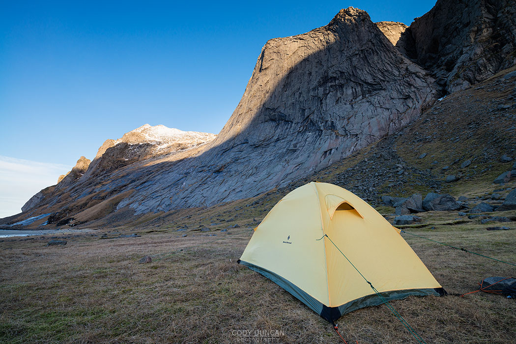 Tent pitched below Helvetestind mountain peak at Bunes beach, Moskenesøy, Lofoten Islands, Norway