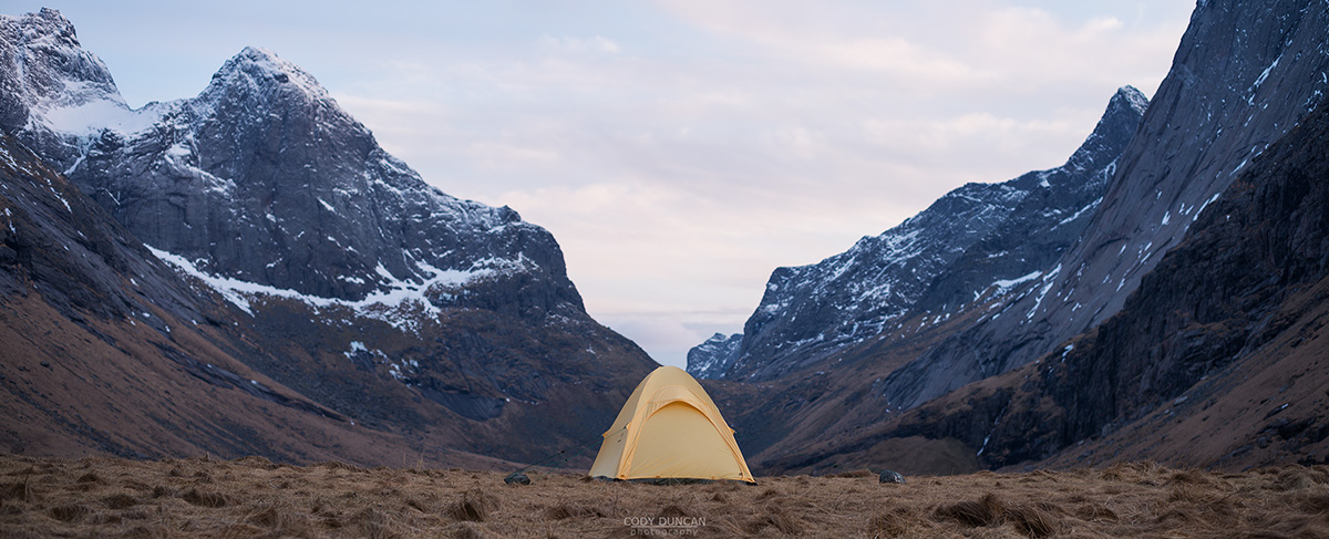 Tent with scenic mountain backdrop while wild camping at Horseid beach, Moskenesøy, Lofoten Islands, Norway