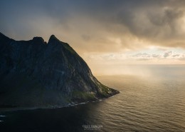Mountain peak rises from sea as viewed from Ryten, Lofoten Islands, Norway