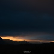 Ray of light silhouettes stormy mountain landscape, Vestvagoy, Lofoten islands, Norway