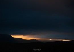 Ray of light silhouettes stormy mountain landscape, Vestvagoy, Lofoten islands, Norway