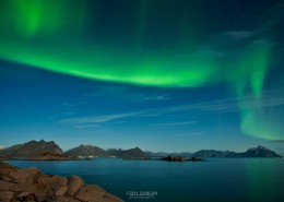 Northern Lights fill sky above mountains of Lofoten Islands, Norway