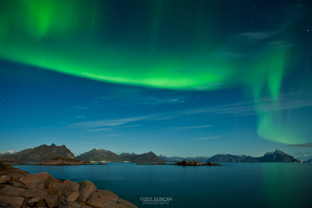 Northern Lights fill sky above mountains of Lofoten Islands, Norway