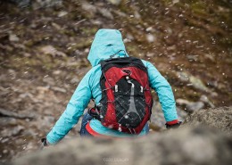 Female hiker is summer snow flurry near summit of Festvågtind, Austvågøy, Lofoten Islands, Norway