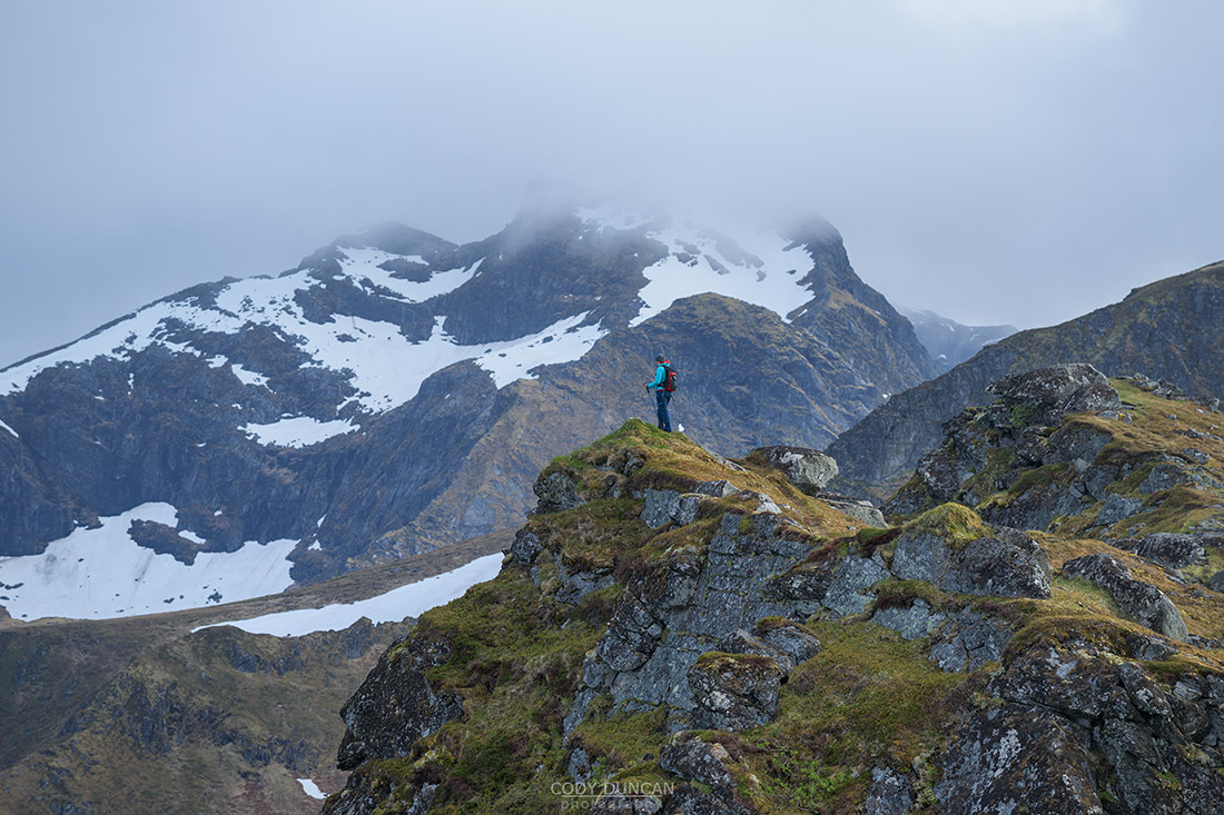 Hiker with view mountain view from Ytresandheia, Moskenesøy, Lofoten Islands, Norway