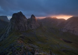 Rays of light illuminate Kråkhammartind (732m) from summit of Markan (602m), Moskenesøy, Lofoten Islands, Norway