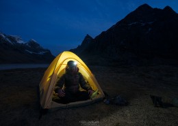 tent illuminated at night while wild camping at scenic Horseid beach, Moskenesøy, Lofoten Islands, Norway