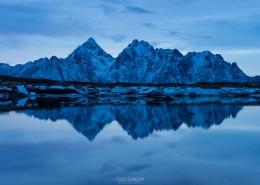Reflection of Vågakallen mountain peak over coastline, Vestvågøy, Lofoten Islands, Norway